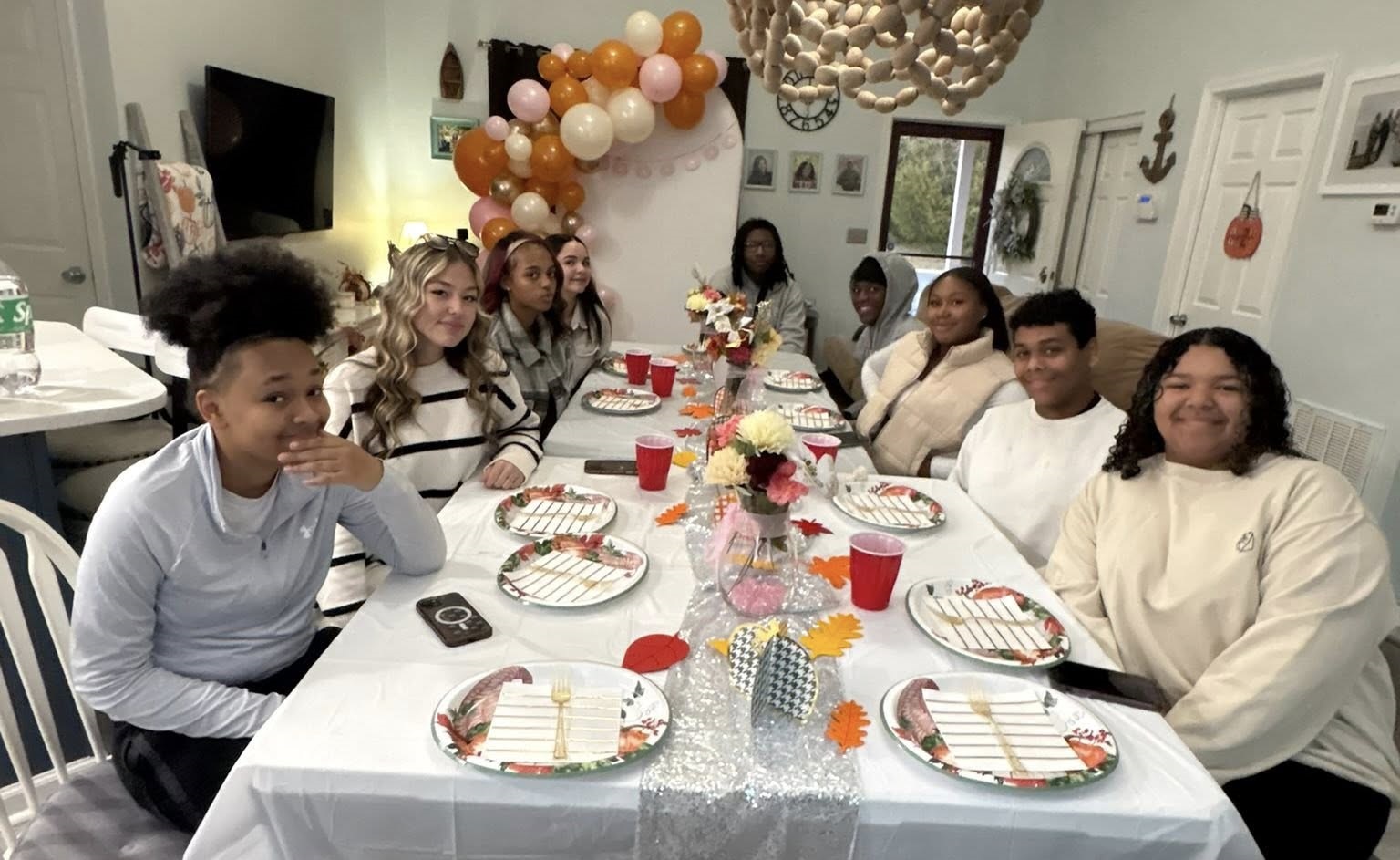 Wide shot of the full Friendsgiving setup including arch and table